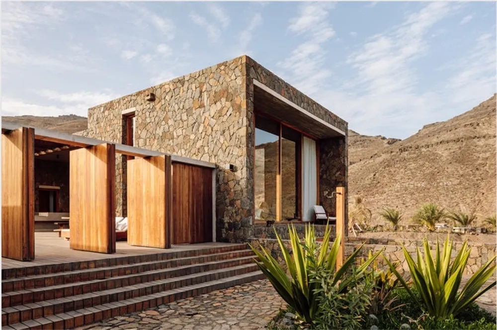 Modern residential building with stone walls and wooden accents.