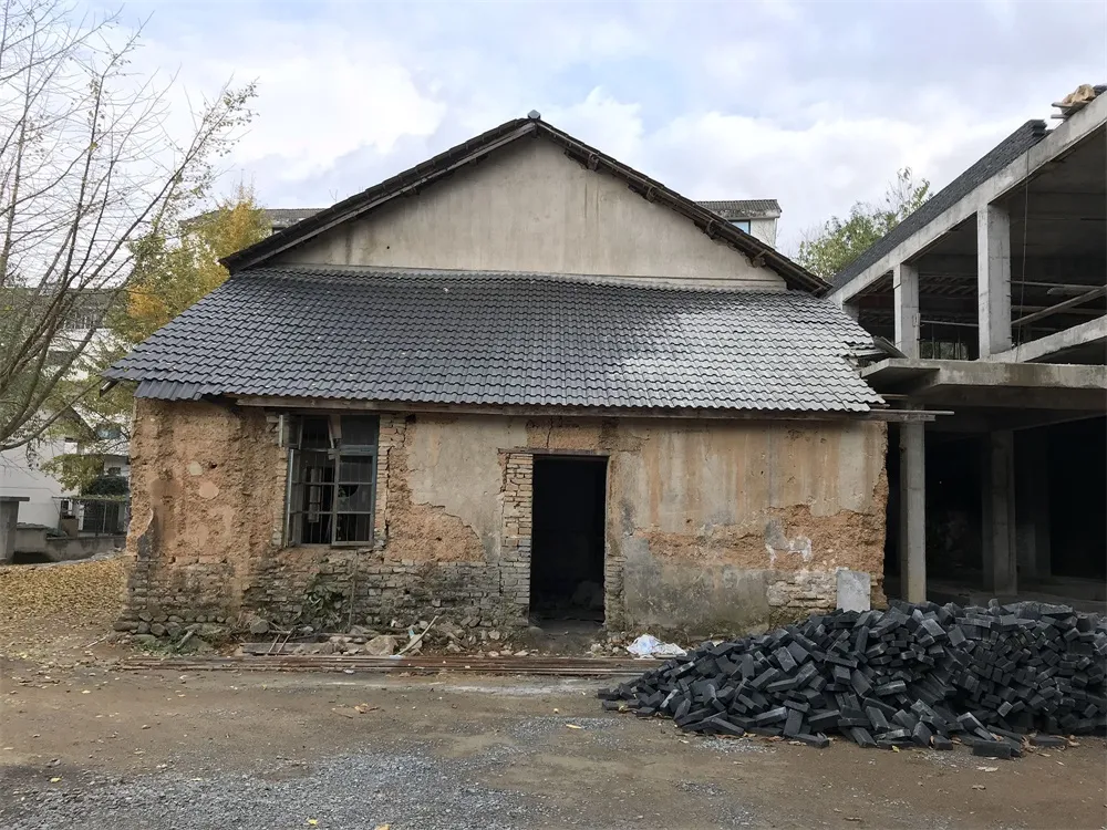 An old, abandoned building with cracked walls and a tiled roof.