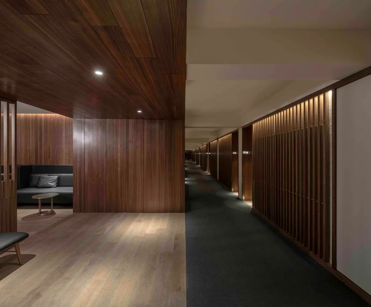 A modern corridor with wooden walls and textured flooring.