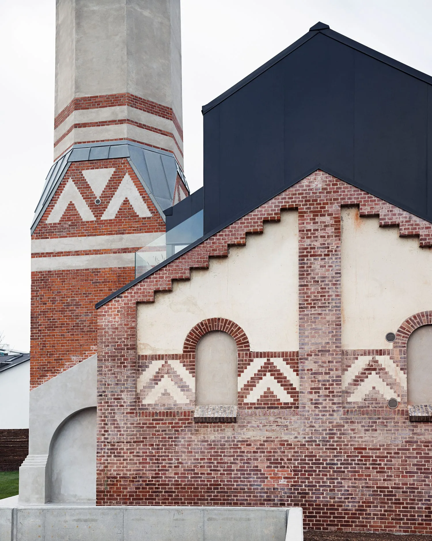 A modern industrial building with brick and concrete materials.