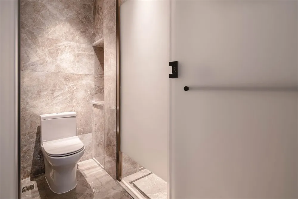A modern bathroom with marble walls and white toilet.