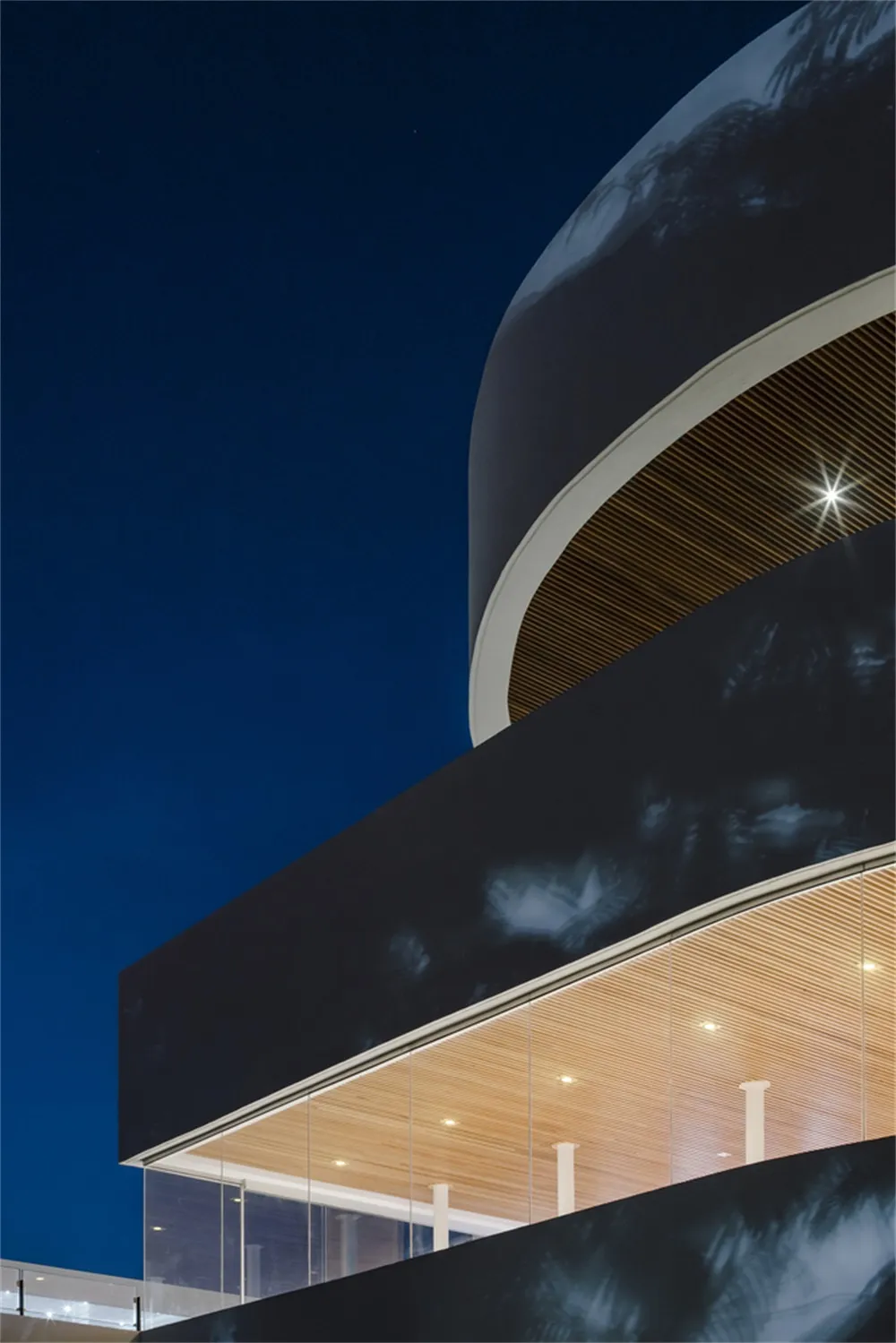 Modern glass architecture building exterior during nighttime with blue sky
