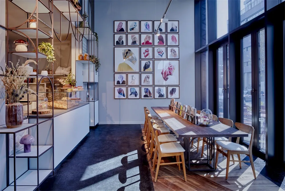 A modern restaurant with a long wooden table and large glass windows