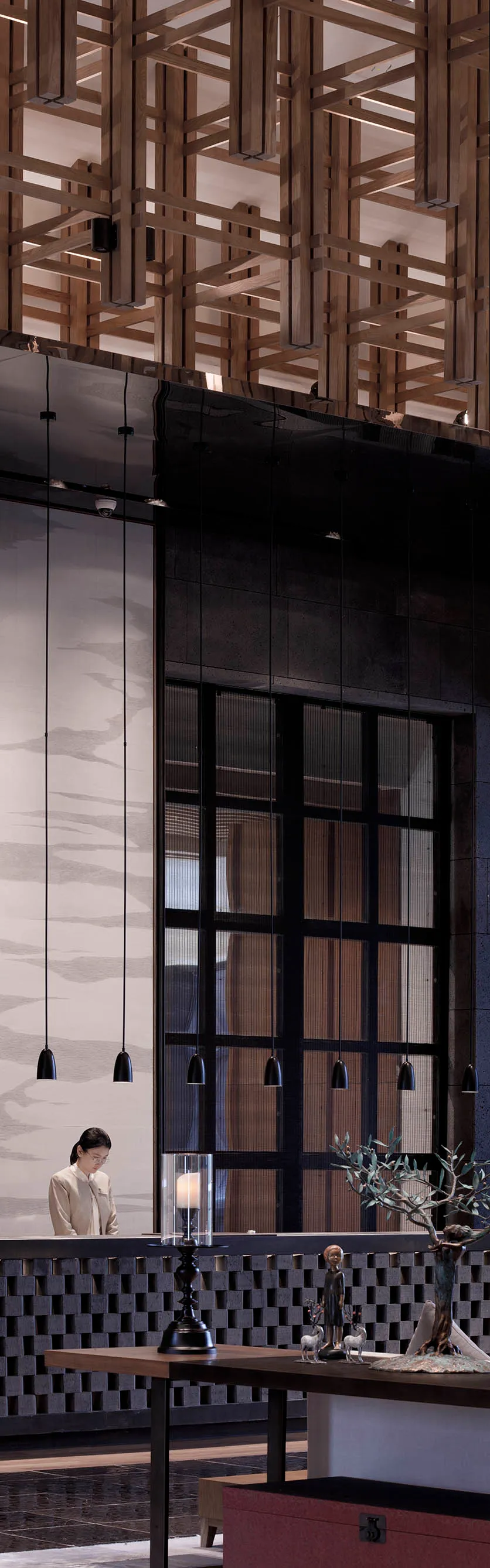 A minimalist modern hotel lobby with wooden elements and hanging lights.
