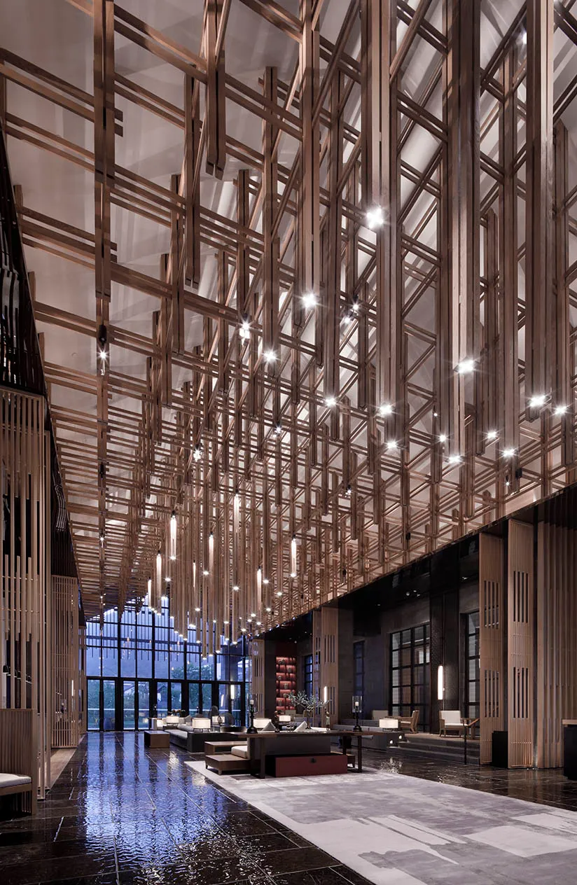A modern lobby with glass walls, high ceiling, and wooden interior decor.