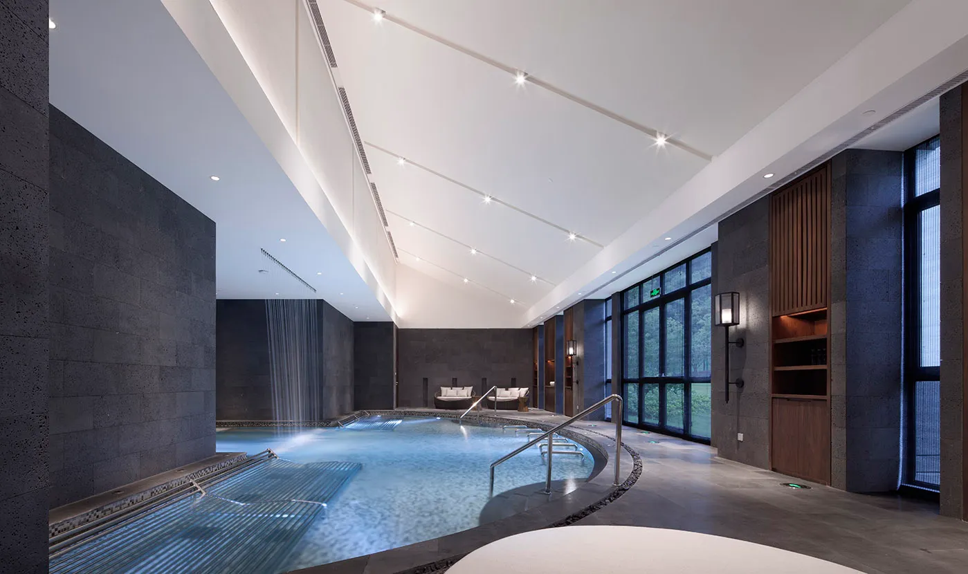 Modern, minimalist spa pool area with concrete walls and flooring.