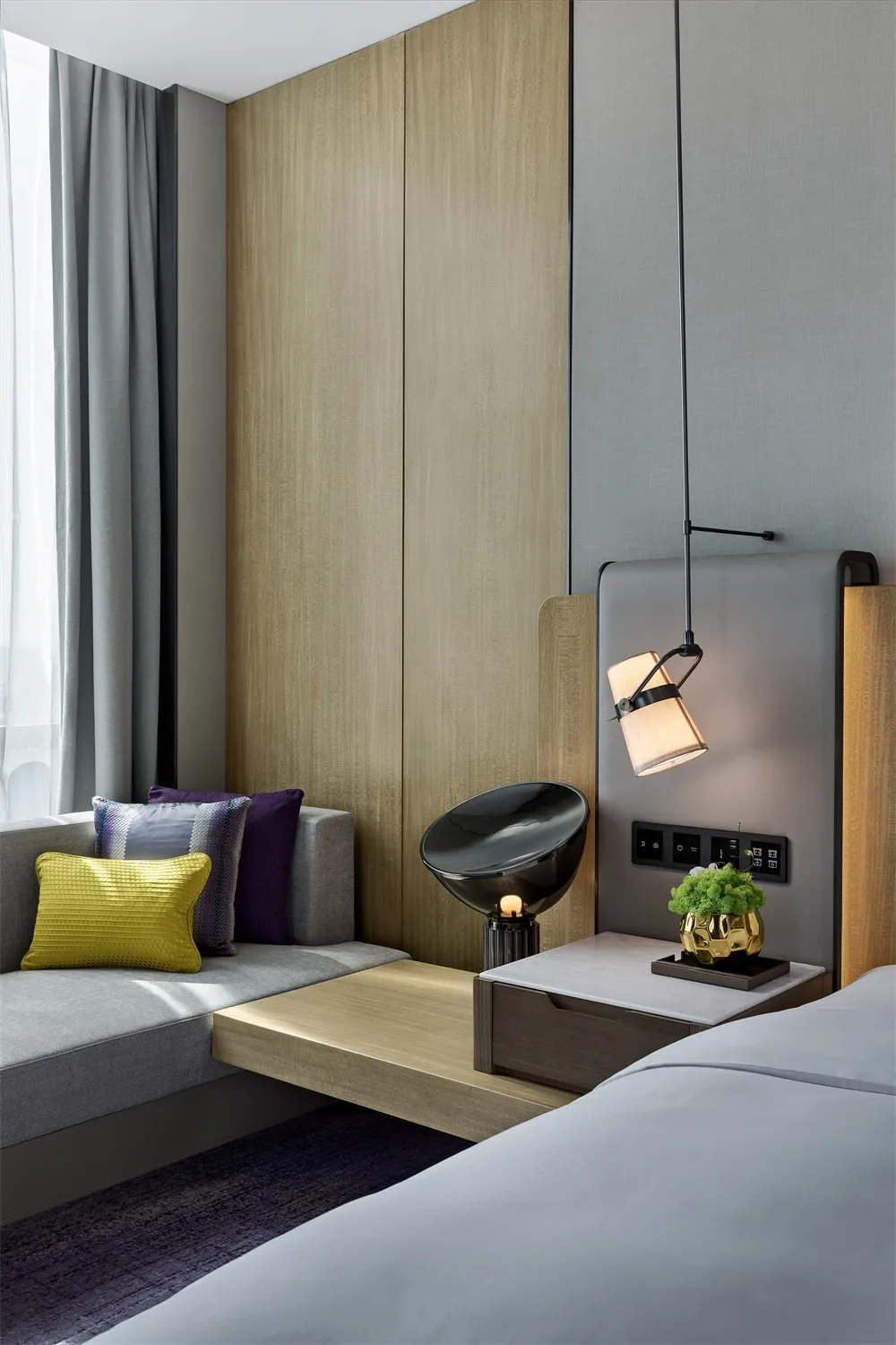 Modern minimalist bedroom featuring minimalist furniture, wooden walls, and a comfortable seating area.