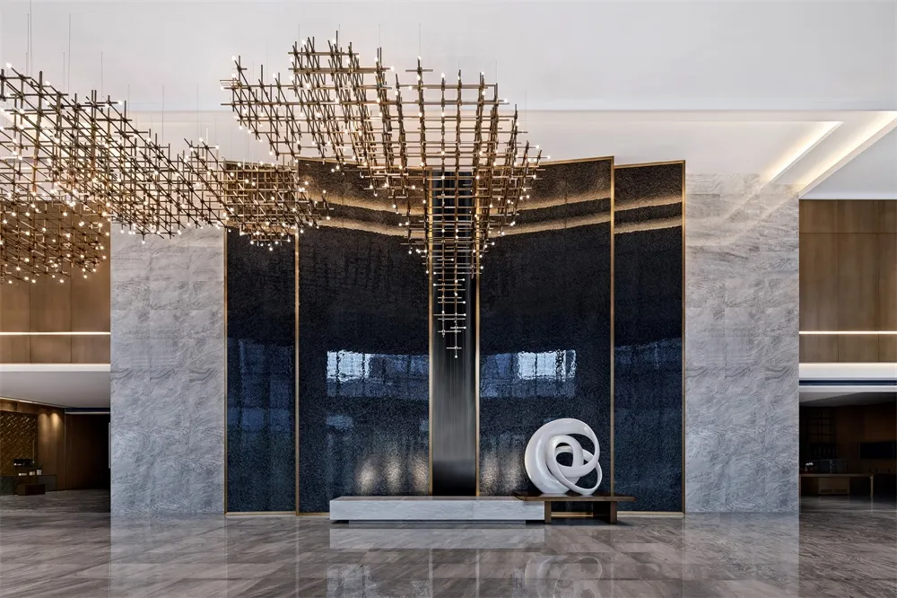 A modern lobby with a contemporary metal chandelier and black glass wall.