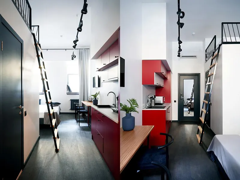 Minimalist residential interior featuring a red kitchen area with an open-plan living space and loft bed.