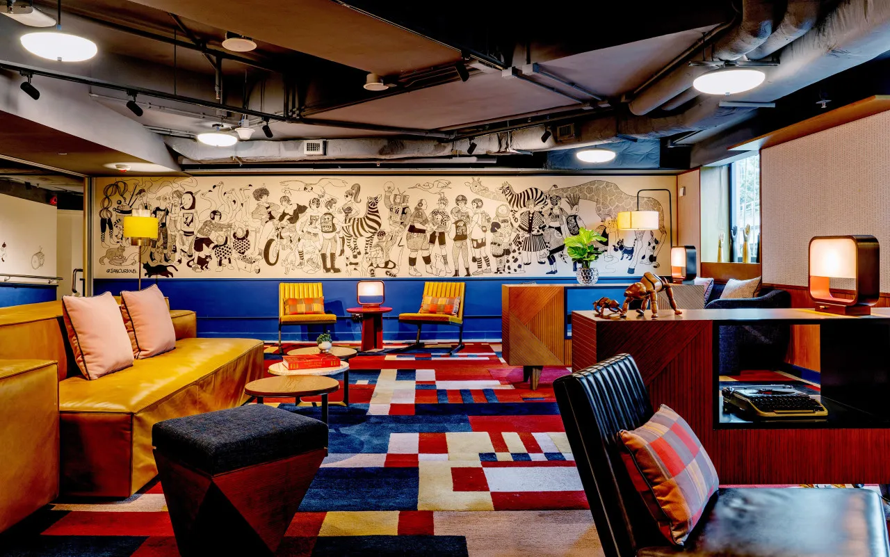 Modern hotel lounge featuring colorful carpet pattern and various seating arrangements.