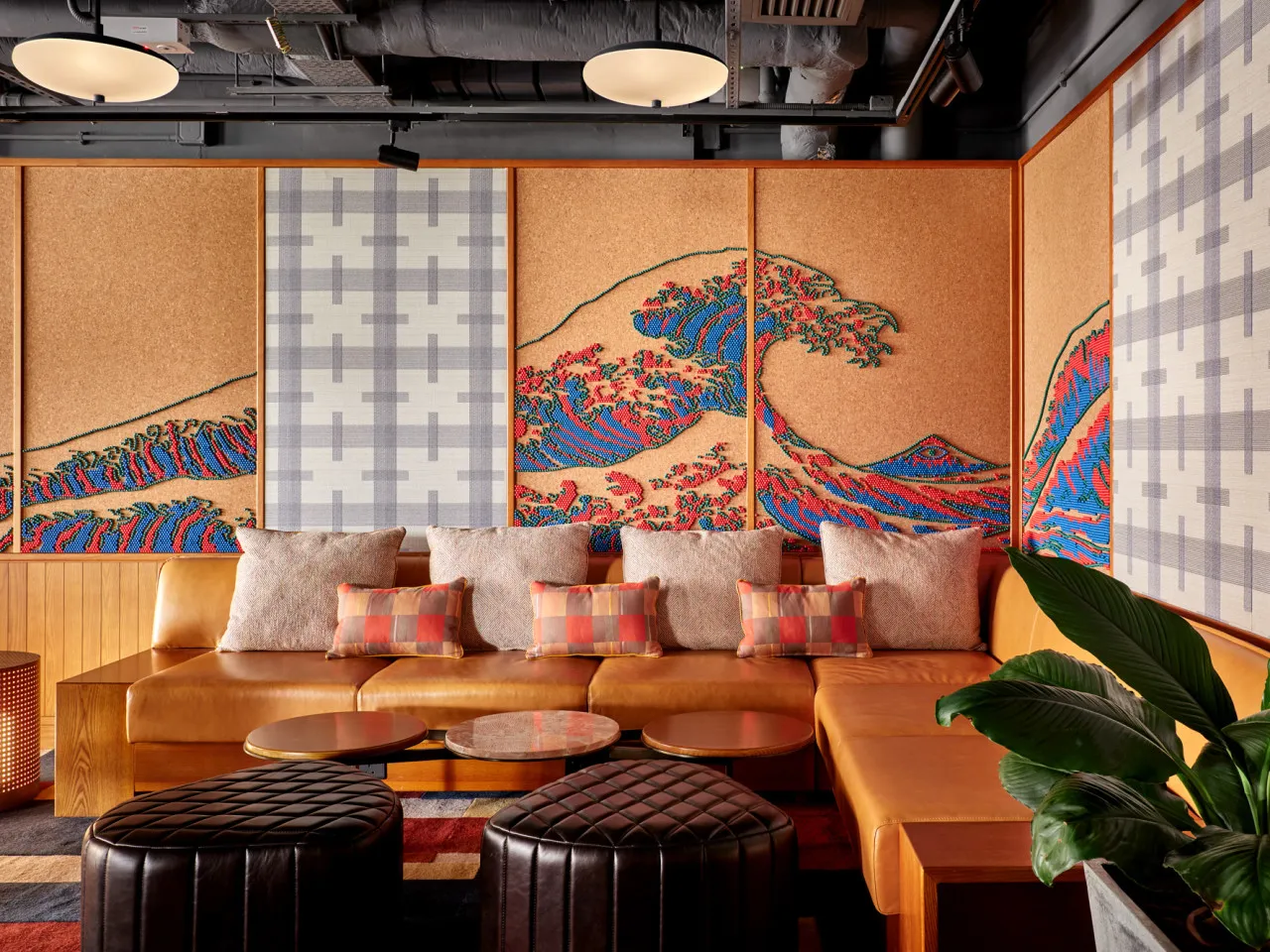 A contemporary retail interior featuring a custom wave pattern on fabric walls and a cozy seating area with plush pillows.
