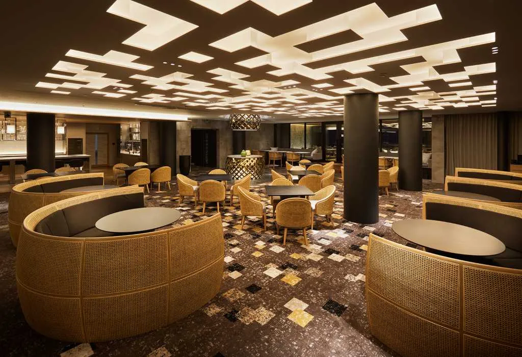 現代咖啡酒吧室內設計,搭配藤編家具與幾何天花板燈具。