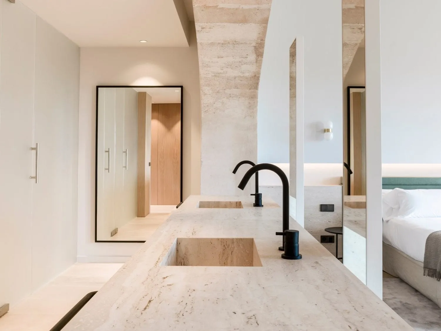 Modern bathroom featuring a minimalist design with marble countertops and black fixtures.