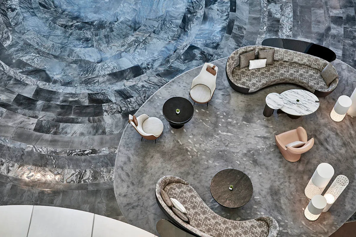 A modern marble lobby featuring elegant seating arrangements and luxurious decor.