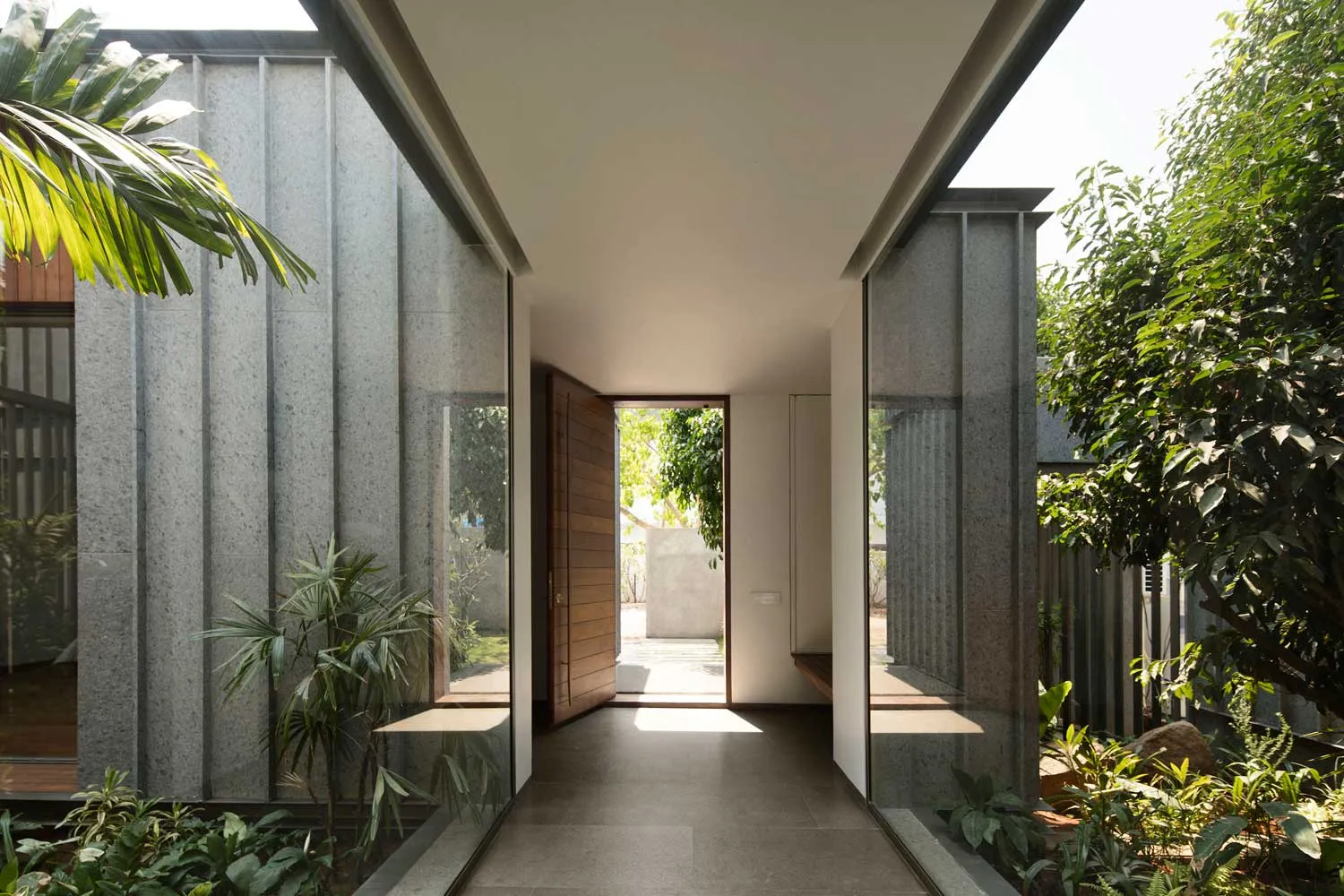 A minimalist entrance with glass panels and a wooden door.