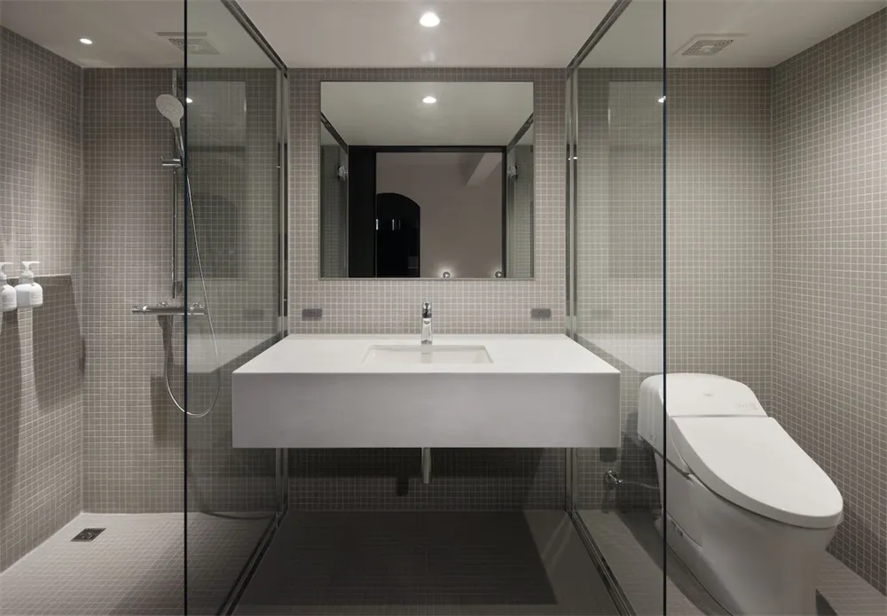 A modern bathroom with minimalist design and ceramic tile walls and floor.