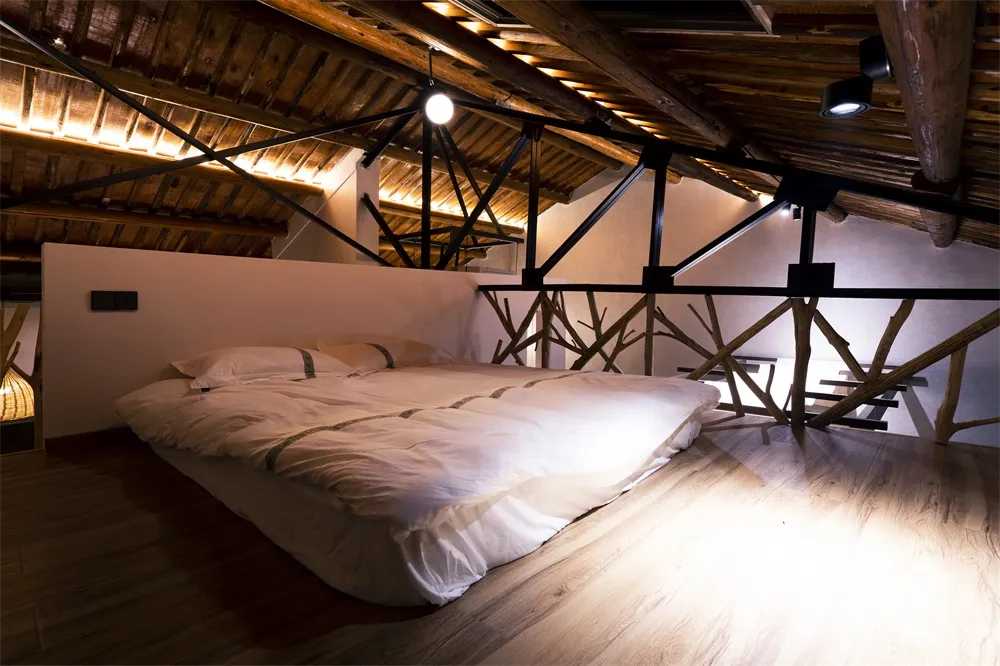 A modern bedroom designed with white lighting, featuring a bed with minimalist bedding and an exposed wooden ceiling with met