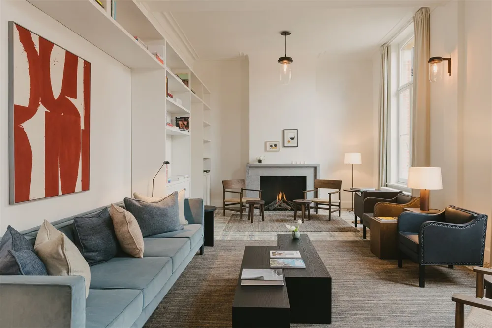 Modern living room featuring a comfortable blue couch, a fireplace, and a coffee table.