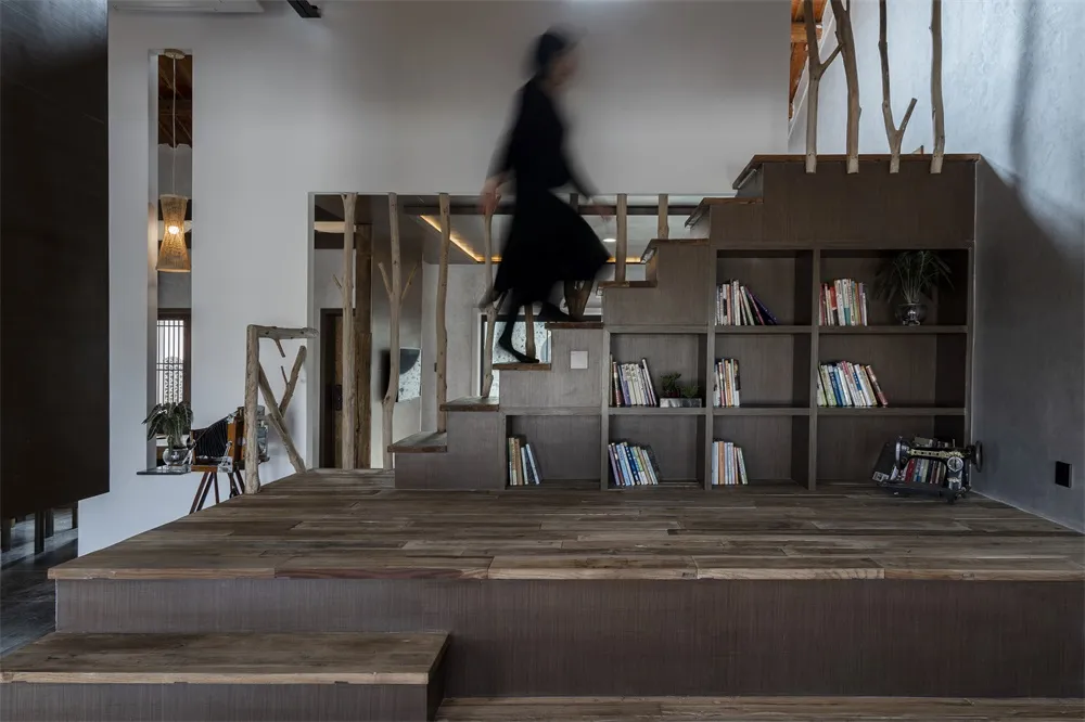 現代辦公室圖書館，木質地板、混凝土牆面與金屬書架單元。