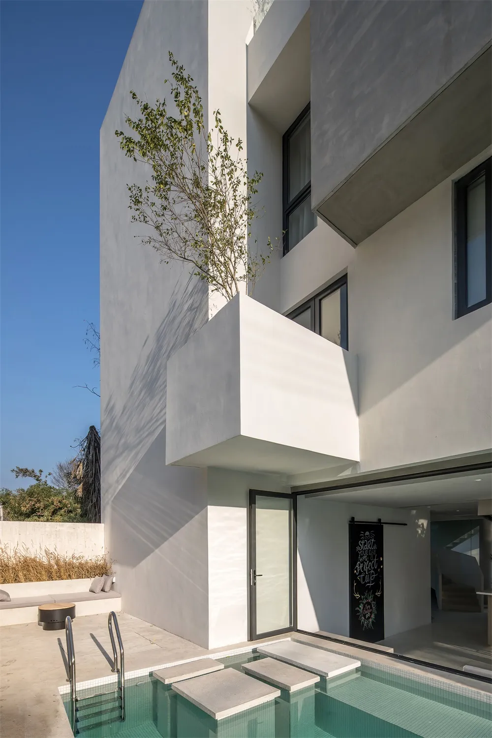 Modern residential building with concrete exterior and large glass windows.