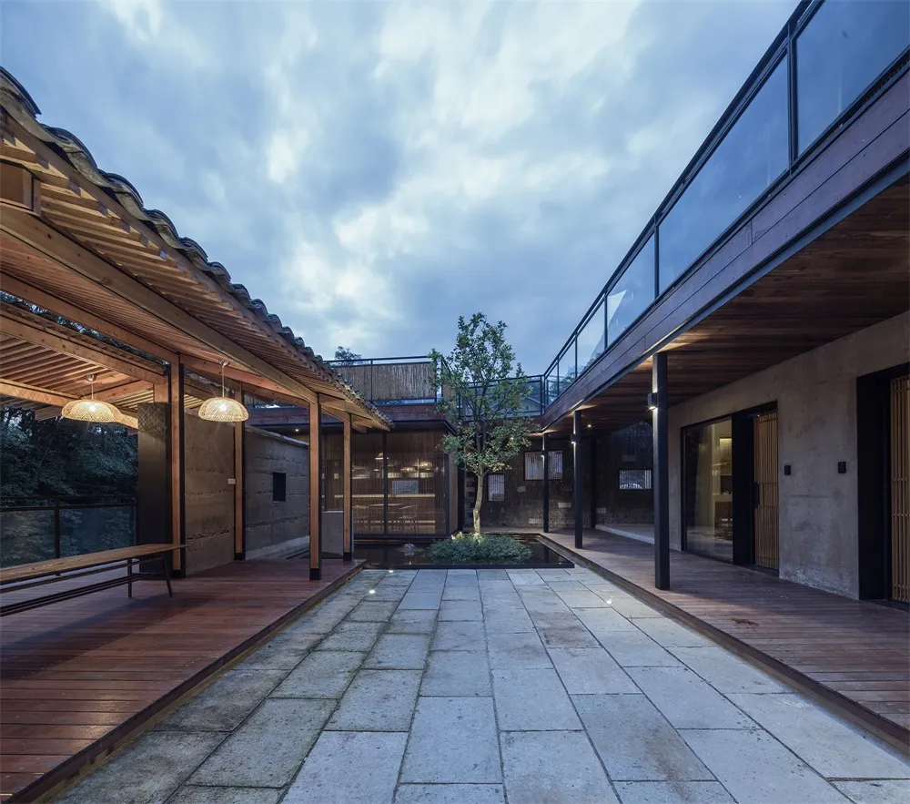 現代工業風住宅室內,採用木質與混凝土材質,並設有中央庭院與樹木。