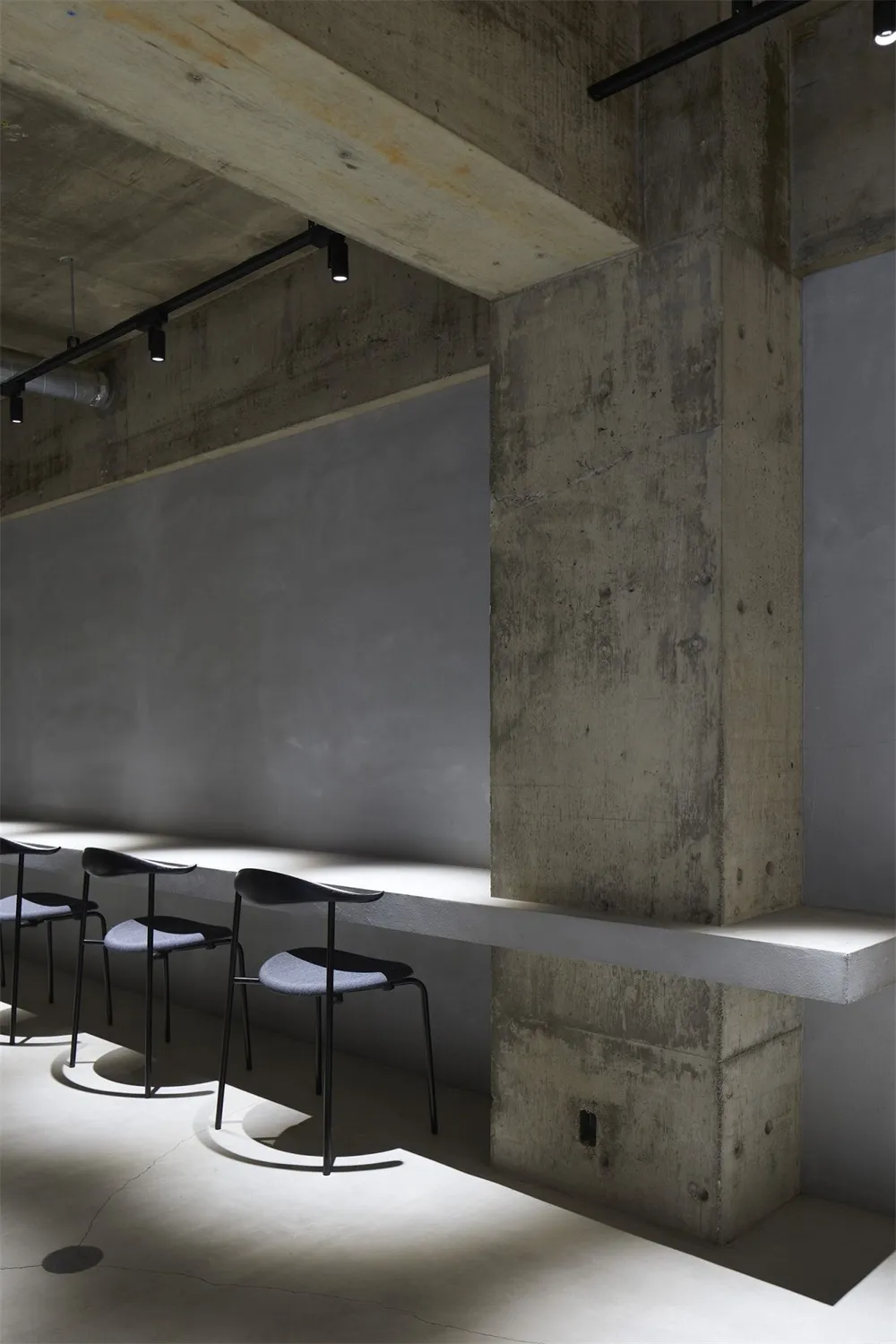 Modernist industrial commercial interior space with concrete walls and minimalist design.