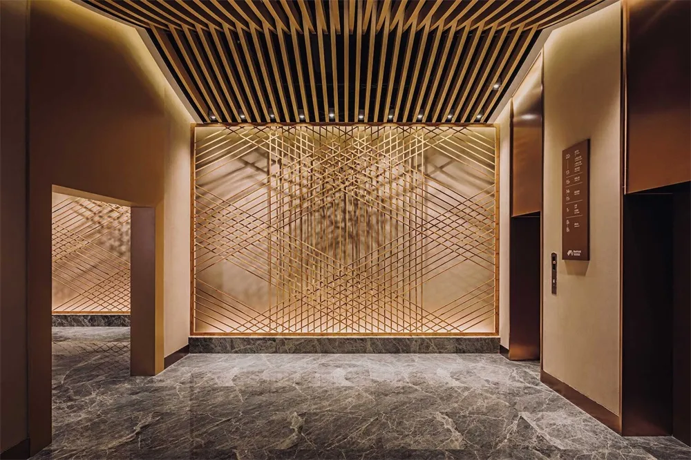Modern hotel lobby featuring metal, glass, and marble materials.