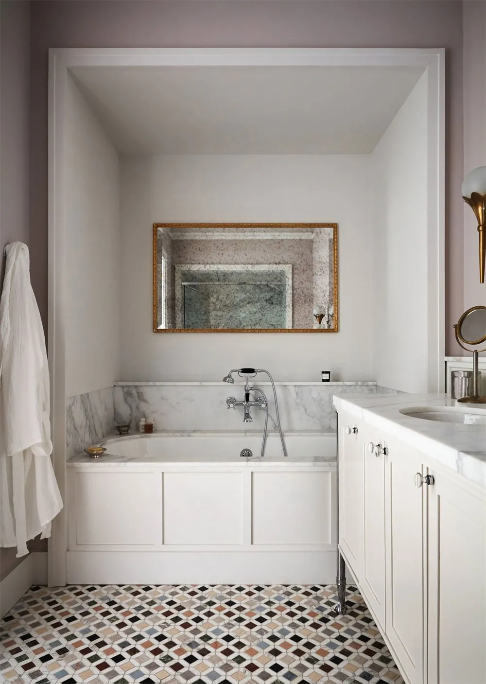 A minimalist bathroom featuring marble walls and a mosaic tile floor.