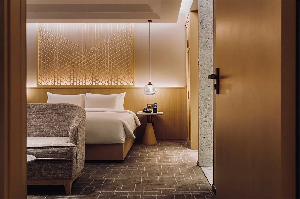 一間現代酒店臥室,擁有木質特色牆與整潔的床鋪。