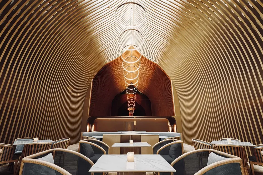 A modern restaurant interior featuring wooden elements and circular light fixtures.