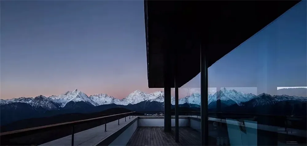 極簡風格陽台，玻璃牆面與雪山景觀。