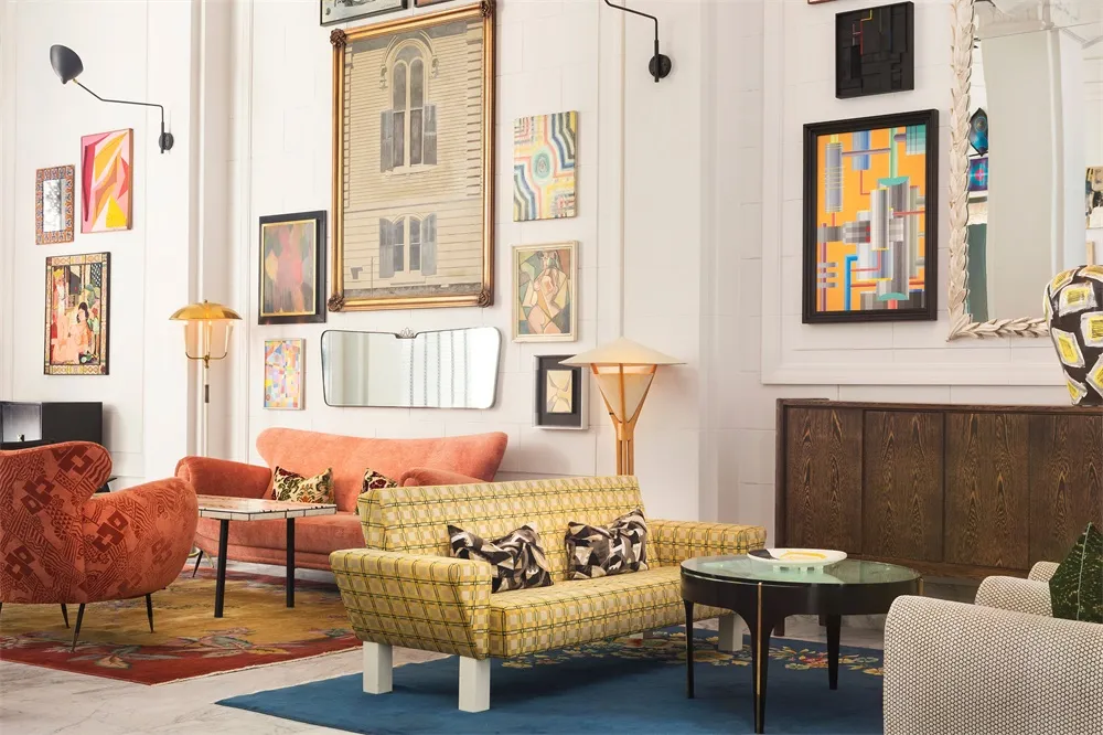 Modern living room featuring mixed-media furniture and colorful artwork on the walls.