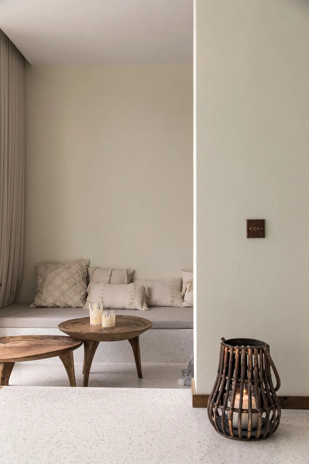 A modern living room with a wooden coffee table, concrete seating area, and natural wood furniture.