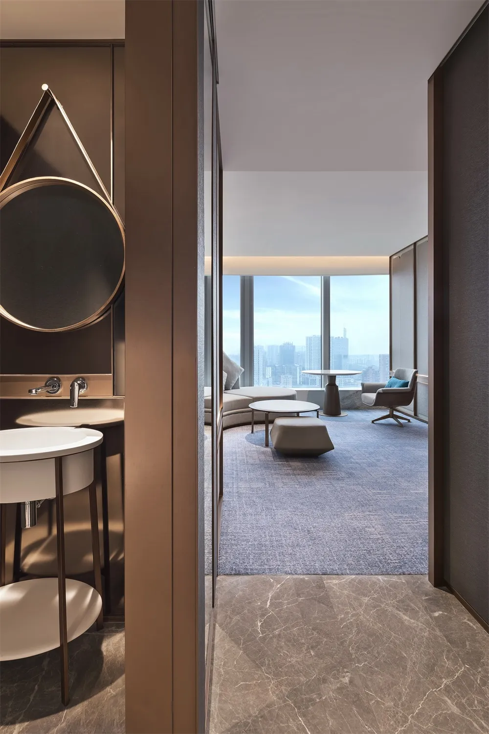 A modern living room featuring marble surfaces, glass elements, and leather furniture.