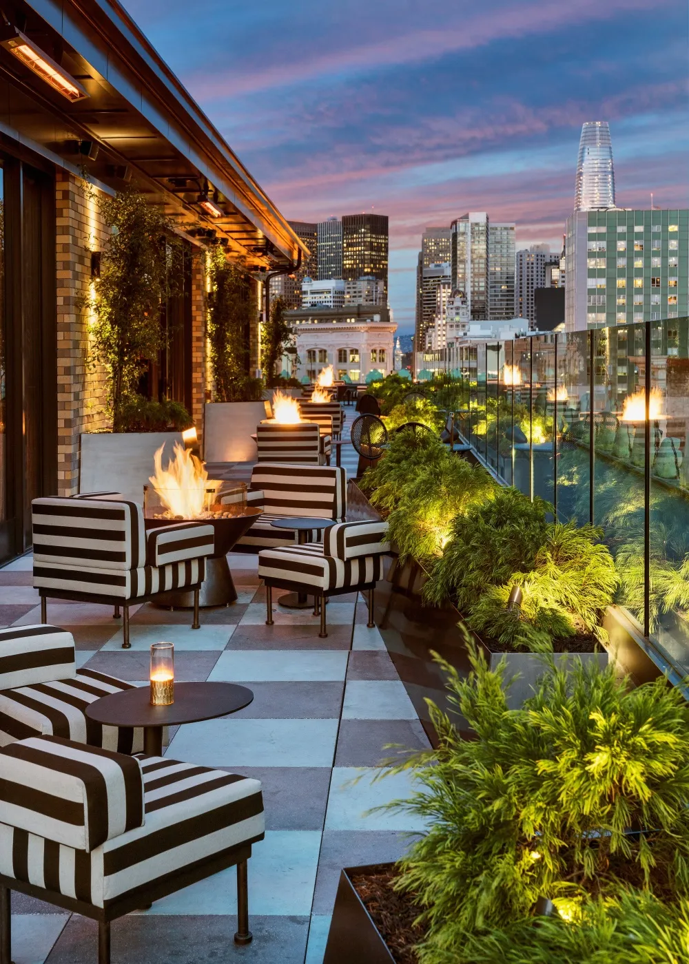A minimalist rooftop lounge featuring brick, glass, and metal elements.