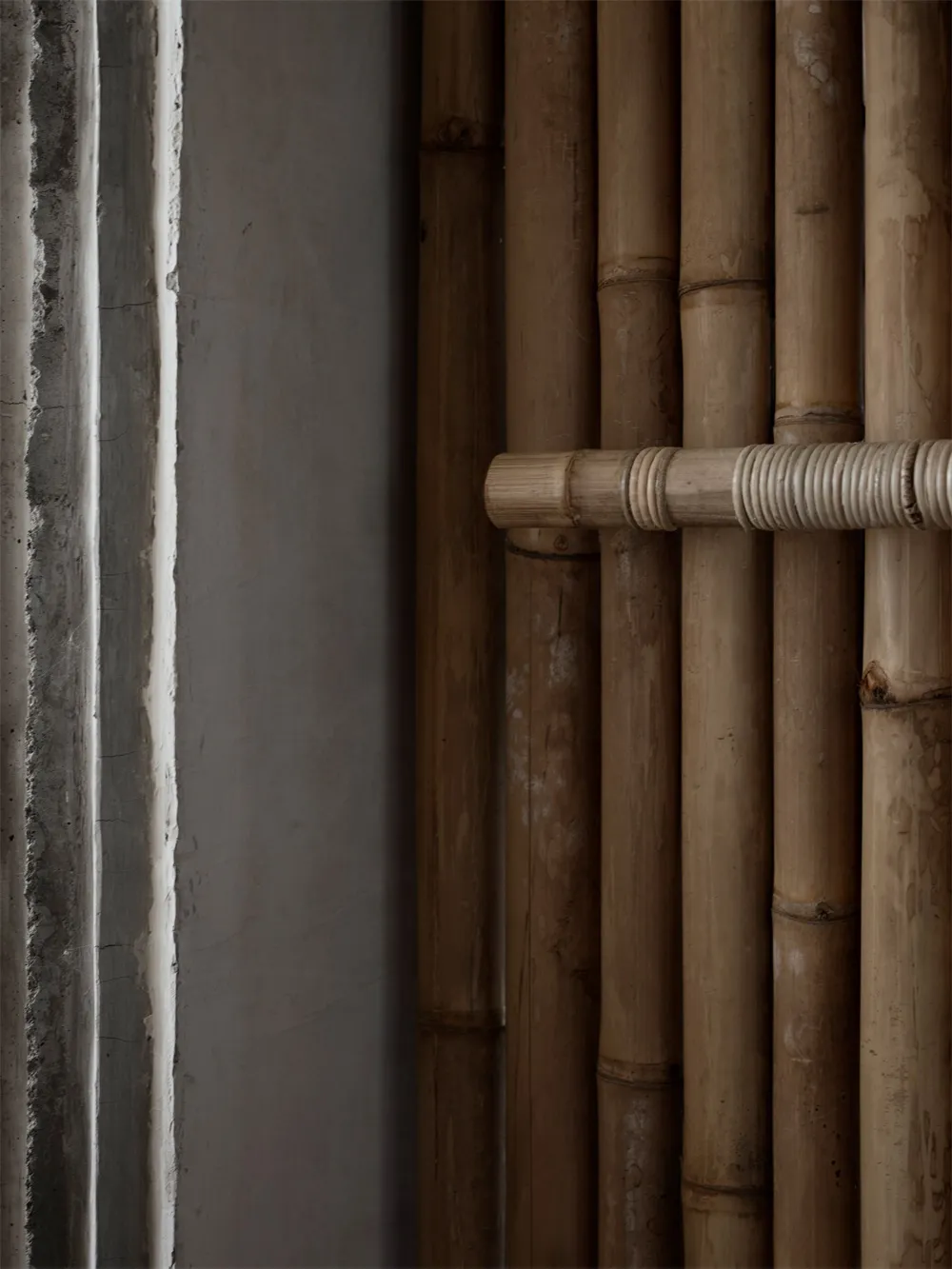 Dark, industrial-style interior space featuring bamboo decor elements.