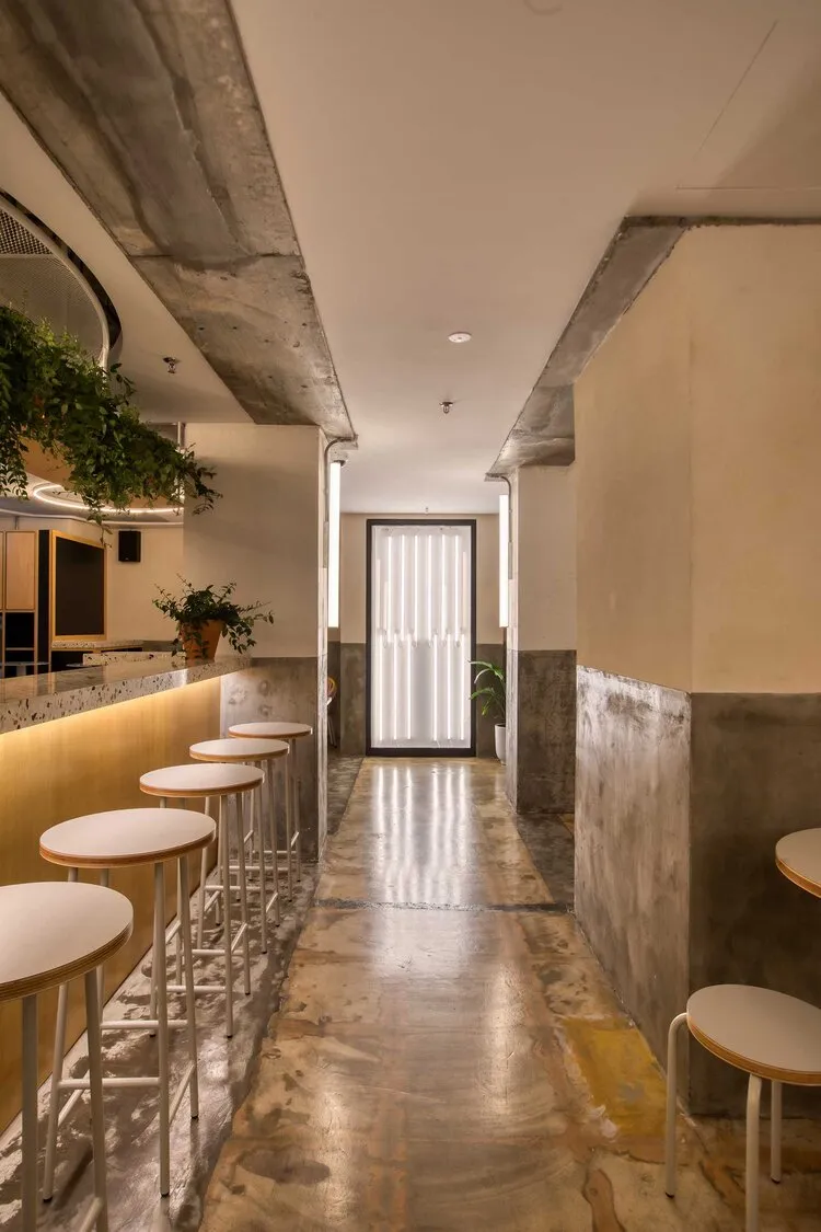 Industrial-style restaurant with concrete walls and wooden seating.