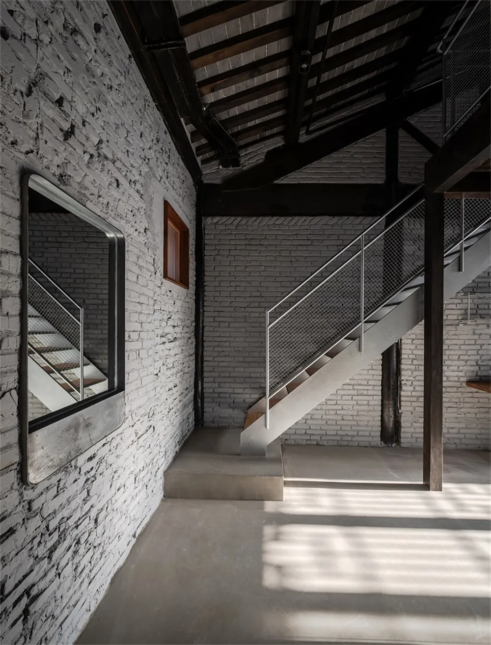 Minimalist interior with concrete, white brick, and steel elements