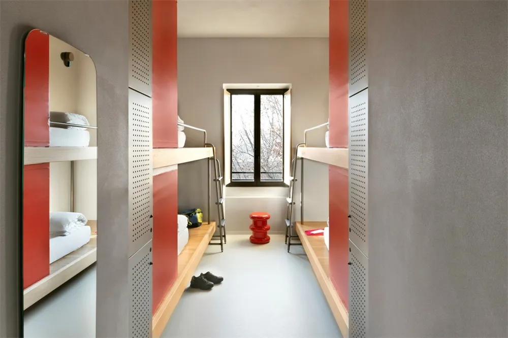 Minimalist bunk room with red accents and shared sleeping area.