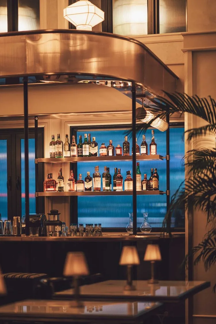 Modern bar interior featuring glass shelves and metal accents.