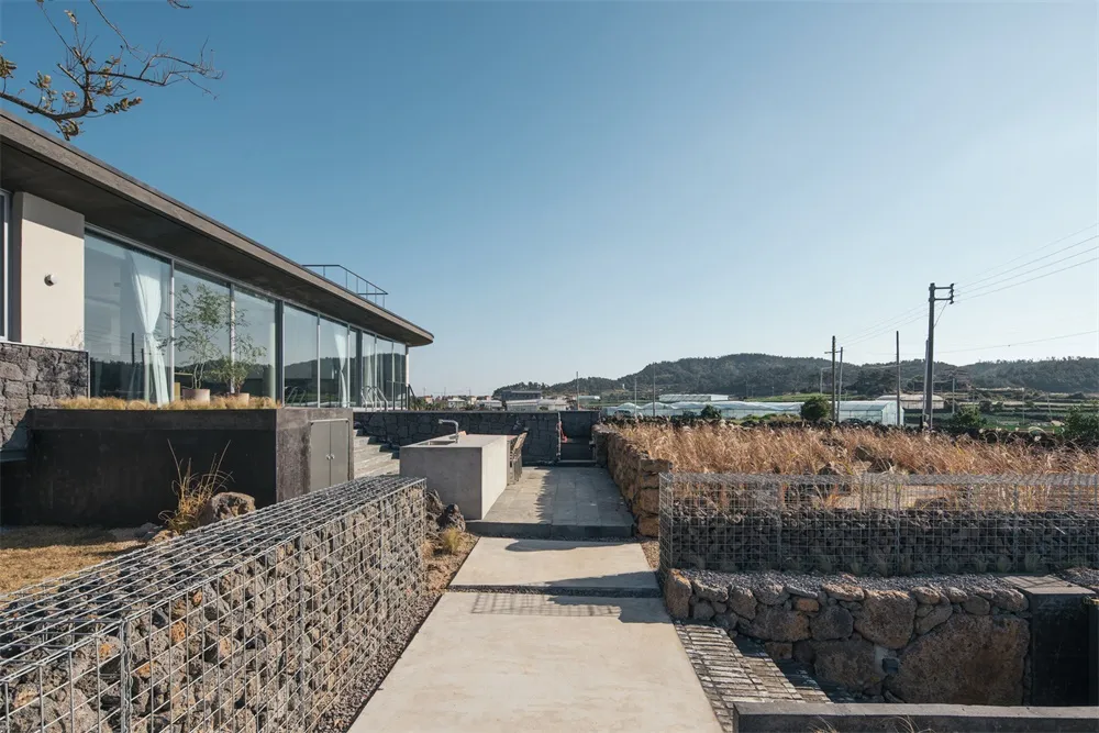A modern residential exterior with concrete and stone materials.