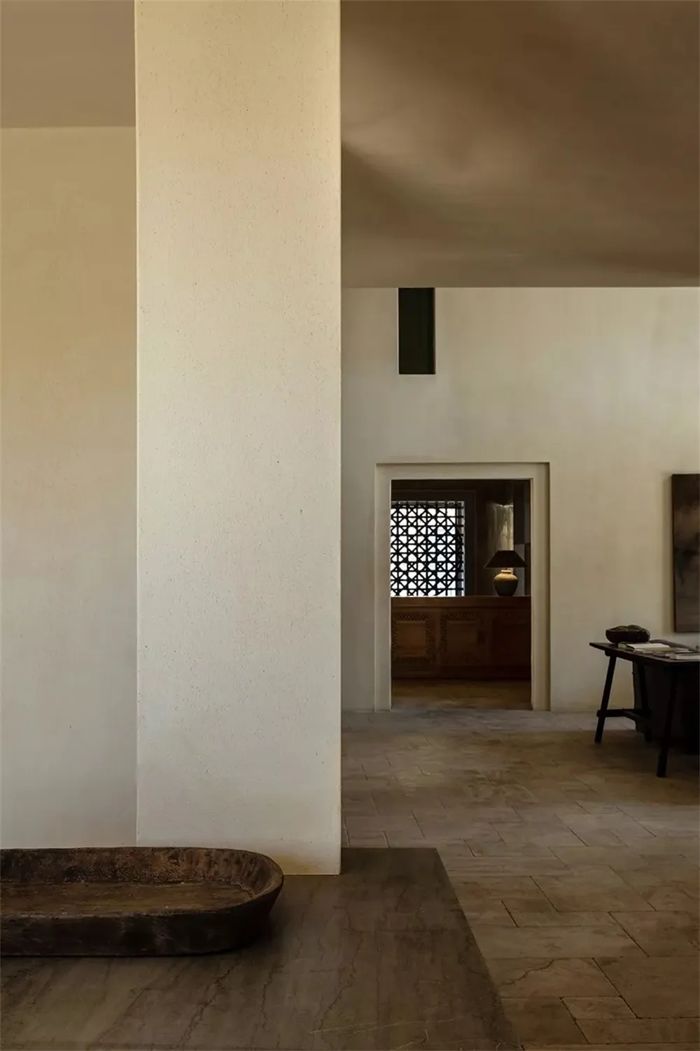 A minimalist living room featuring concrete walls and floors.
