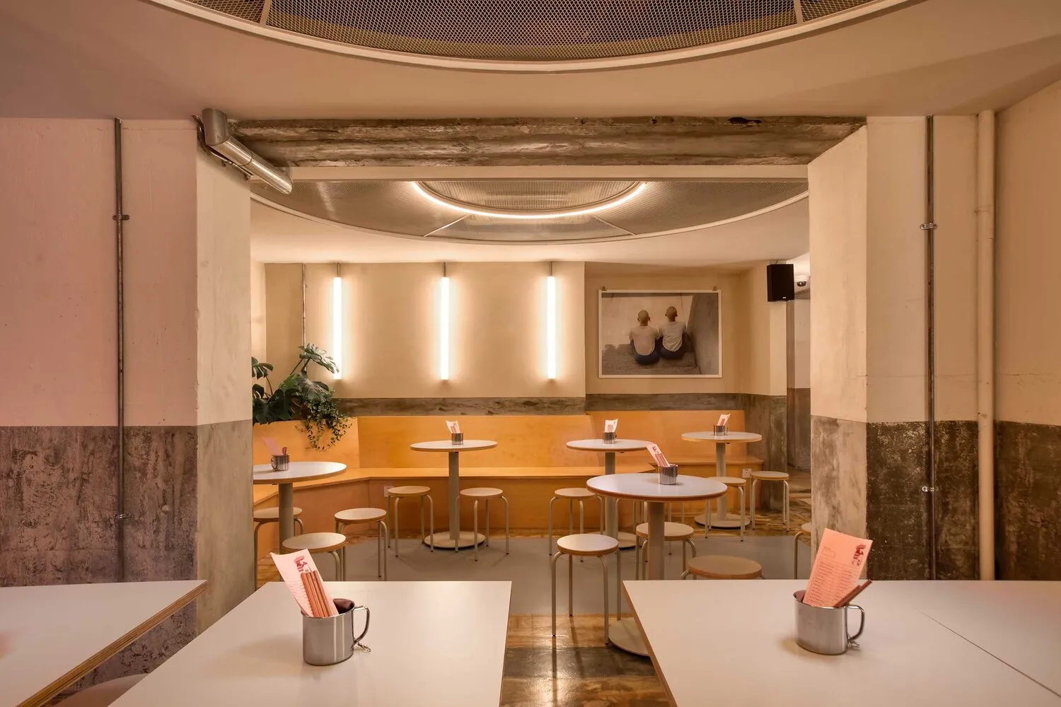 Modern restaurant interior with concrete walls and minimalist design elements.
