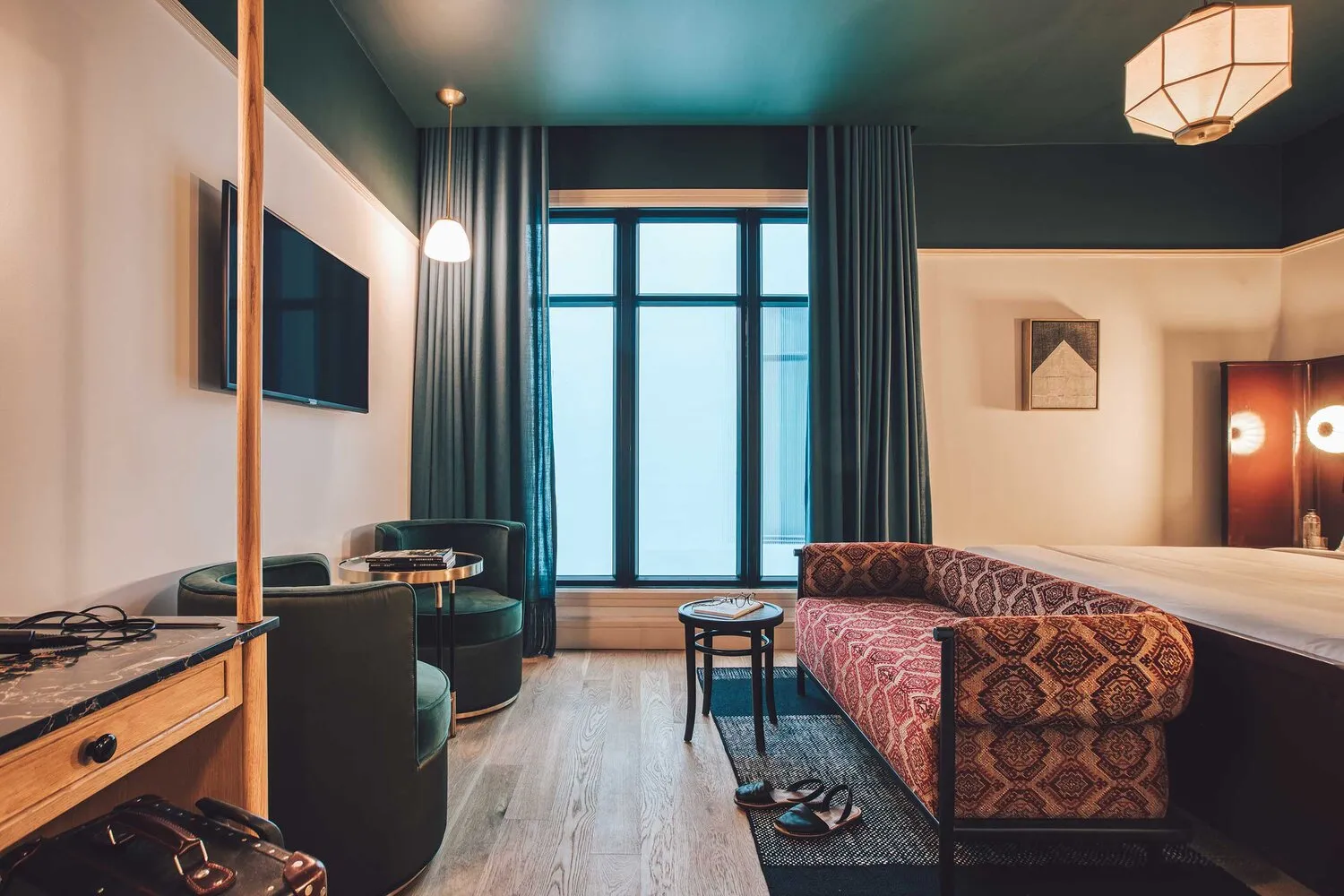 Modern bedroom with wooden flooring and upholstered furniture.
