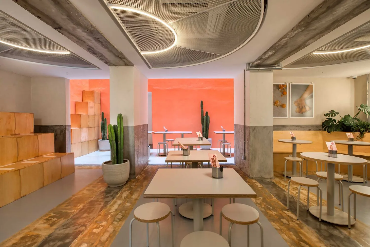 A modern cafe interior with concrete walls, wooden tables, and minimalist design.