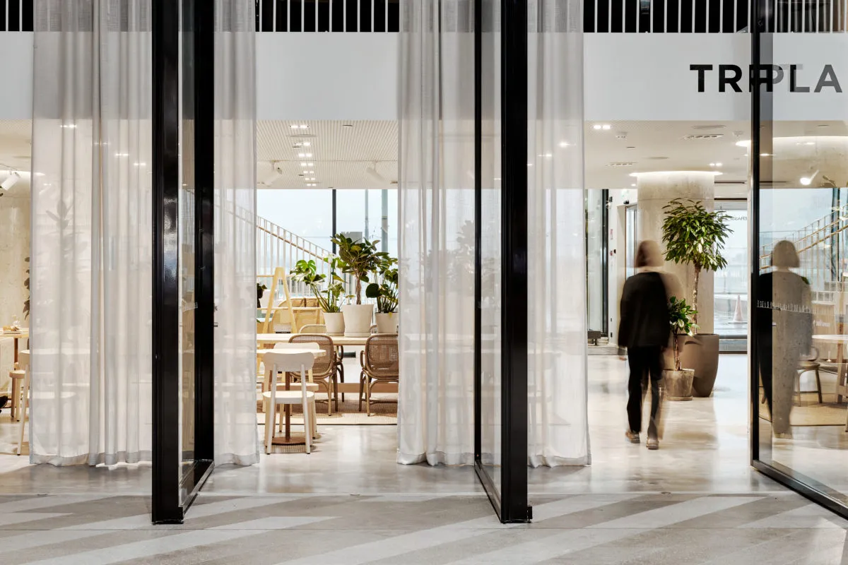 A modern cafe interior with white curtains and contemporary decor.