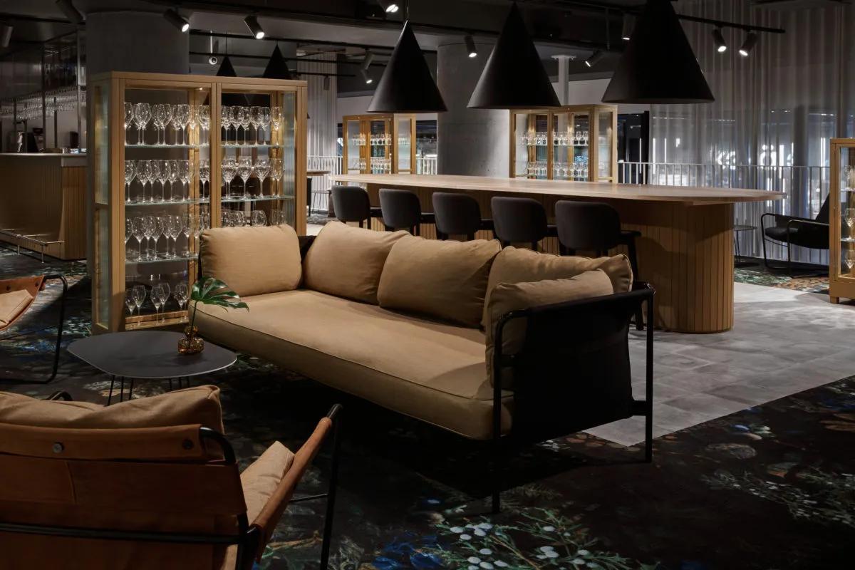 現代酒店大廳,陳設木質家具、玻璃櫃與皮革細節。