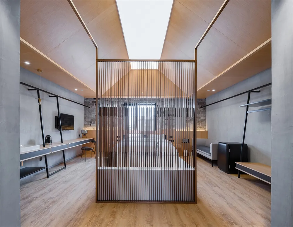 Modern industrial office interior with wood slat wall and concrete floor.