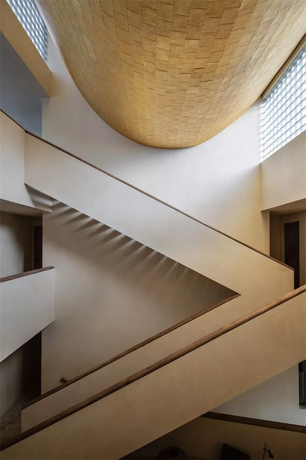 Modern industrial staircase with concrete steps and wooden railings.