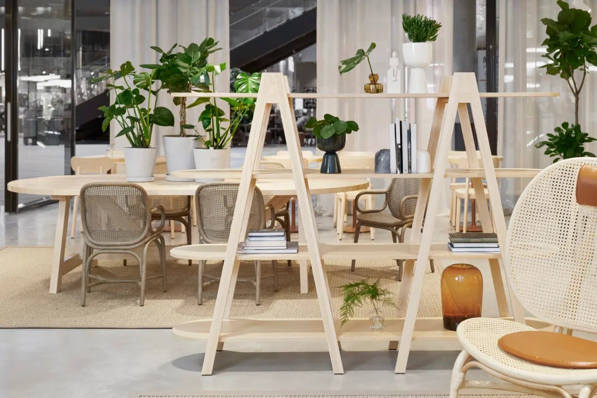 A modern loft office space featuring wooden furniture, concrete flooring, and potted plants.